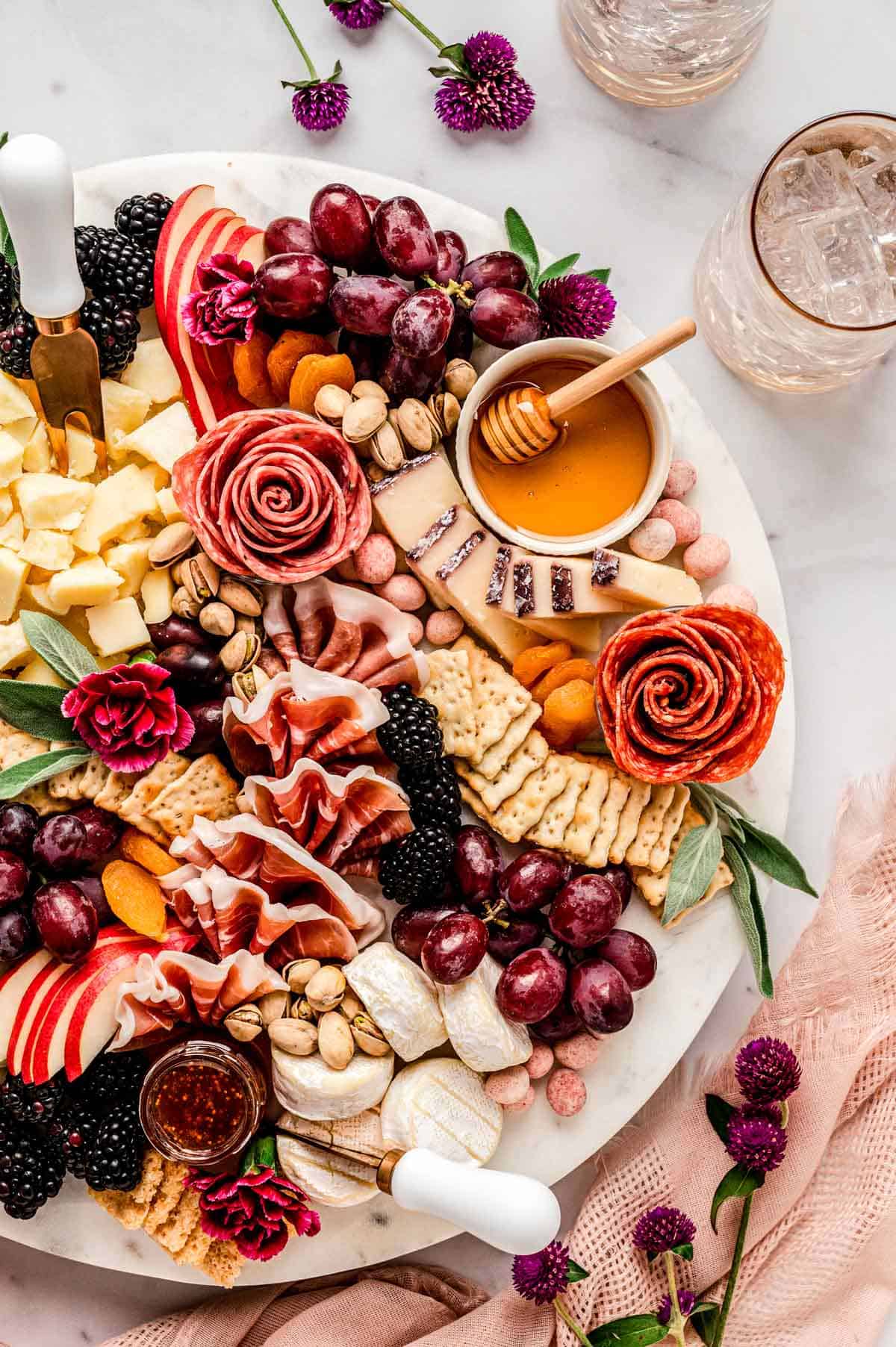 Overhead image of a beautiful charcuterie board with flowers.