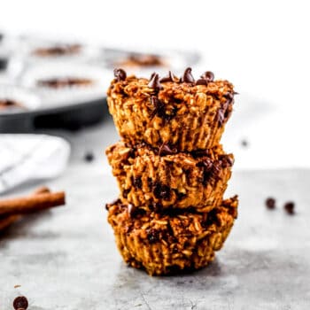 A stack of three healthy pumpkin oatmeal muffins with chocolate chips.