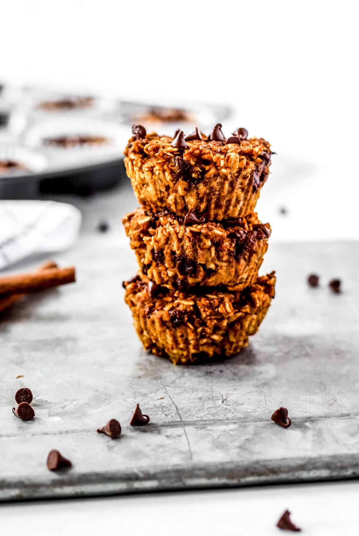 Three healthy pumpkin oatmeal muffins stacked on top of each other.