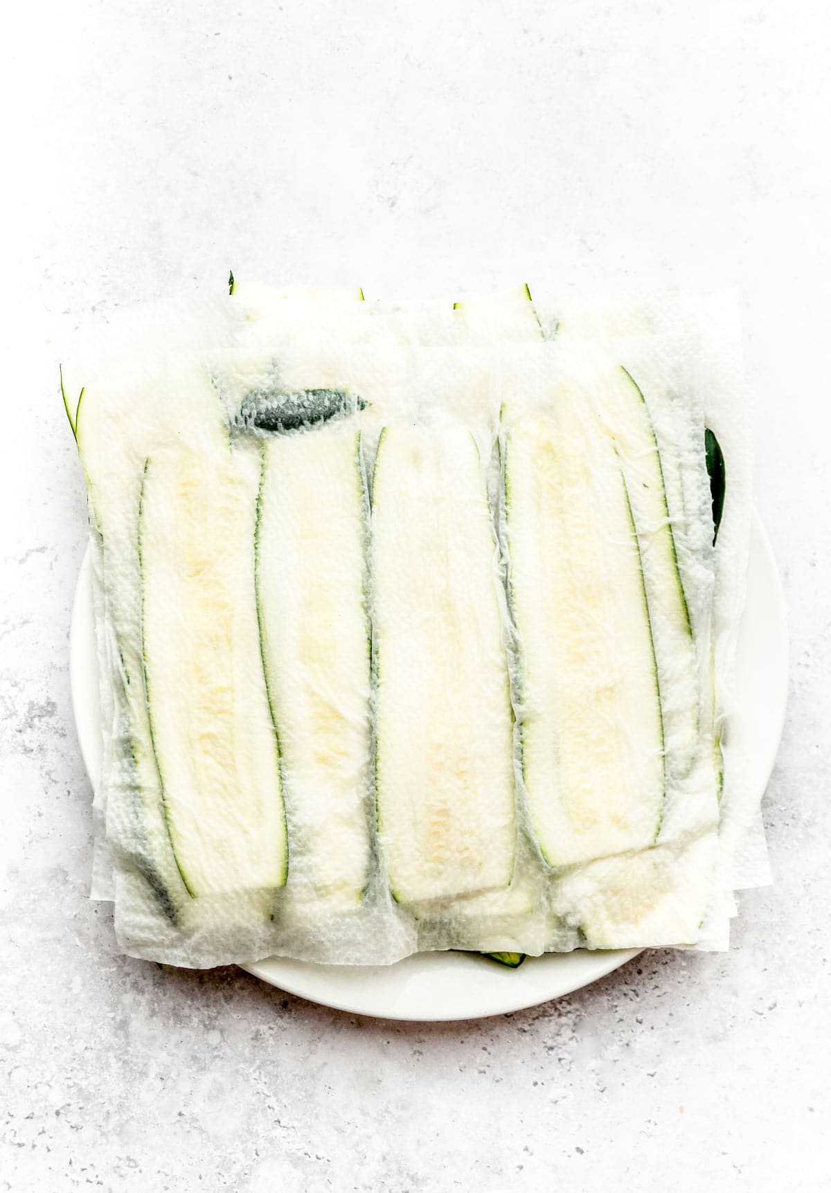 A paper towel absorbing excess moisture from zucchini noodles.