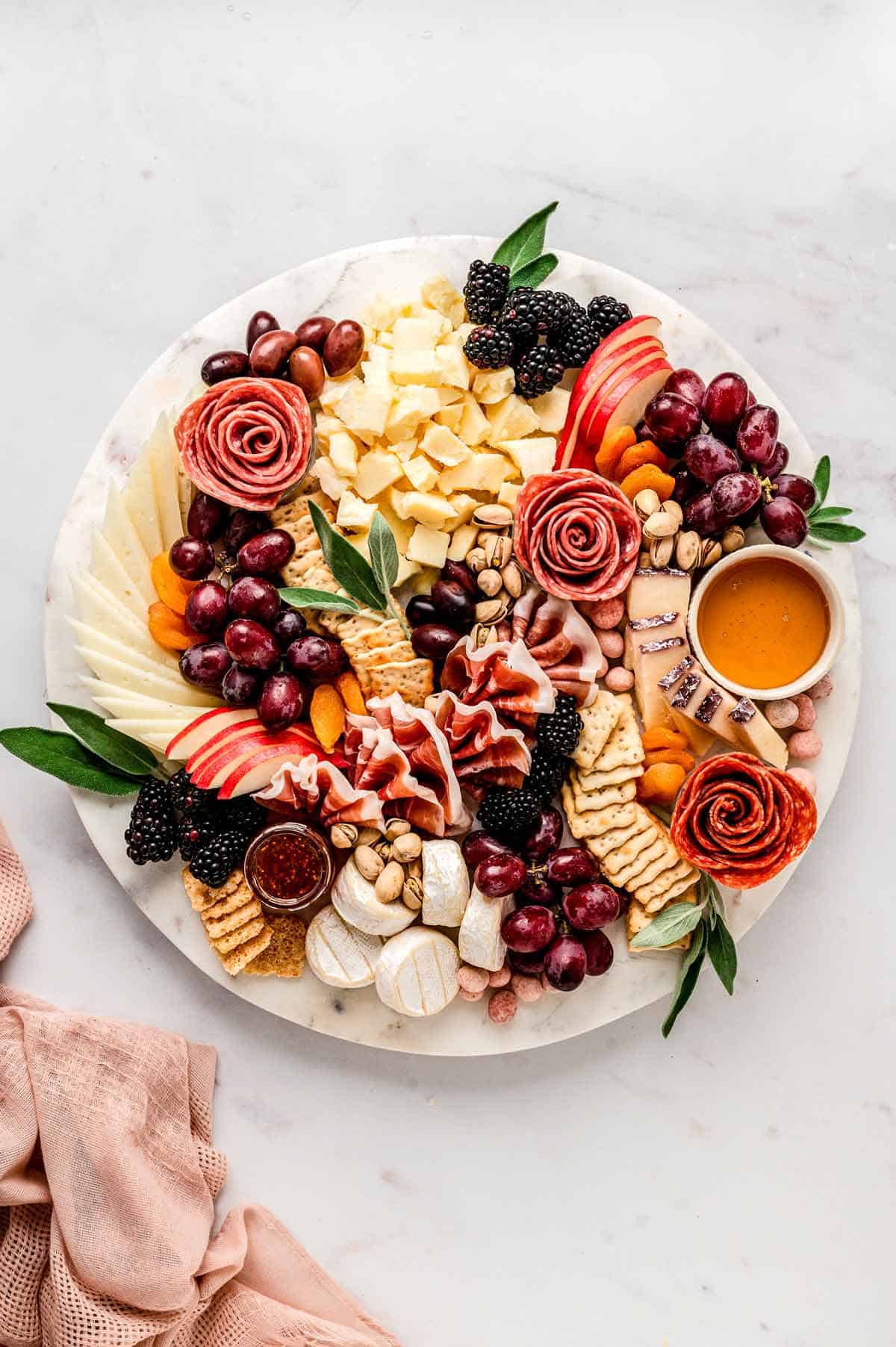 The ultimate charcuterie board with grapes, apples, blackberries, meats, cheese and crackers.