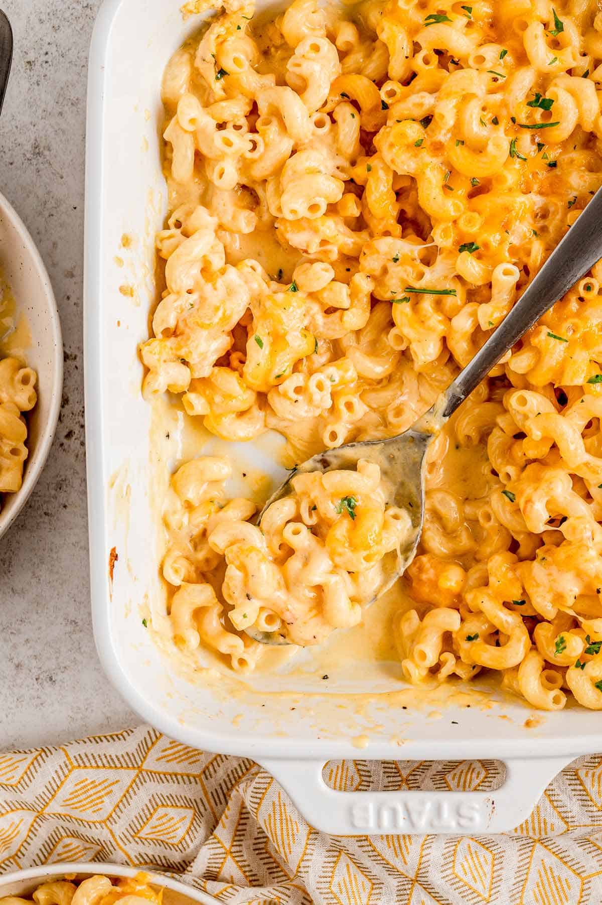 Baked mac and cheese without flour in a casserole dish with a metal spoon.