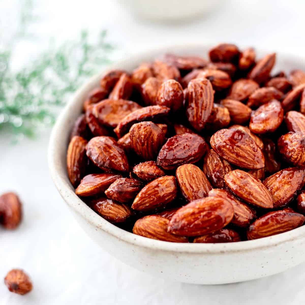 Cinnamon honey roasted almonds in a white bowl.