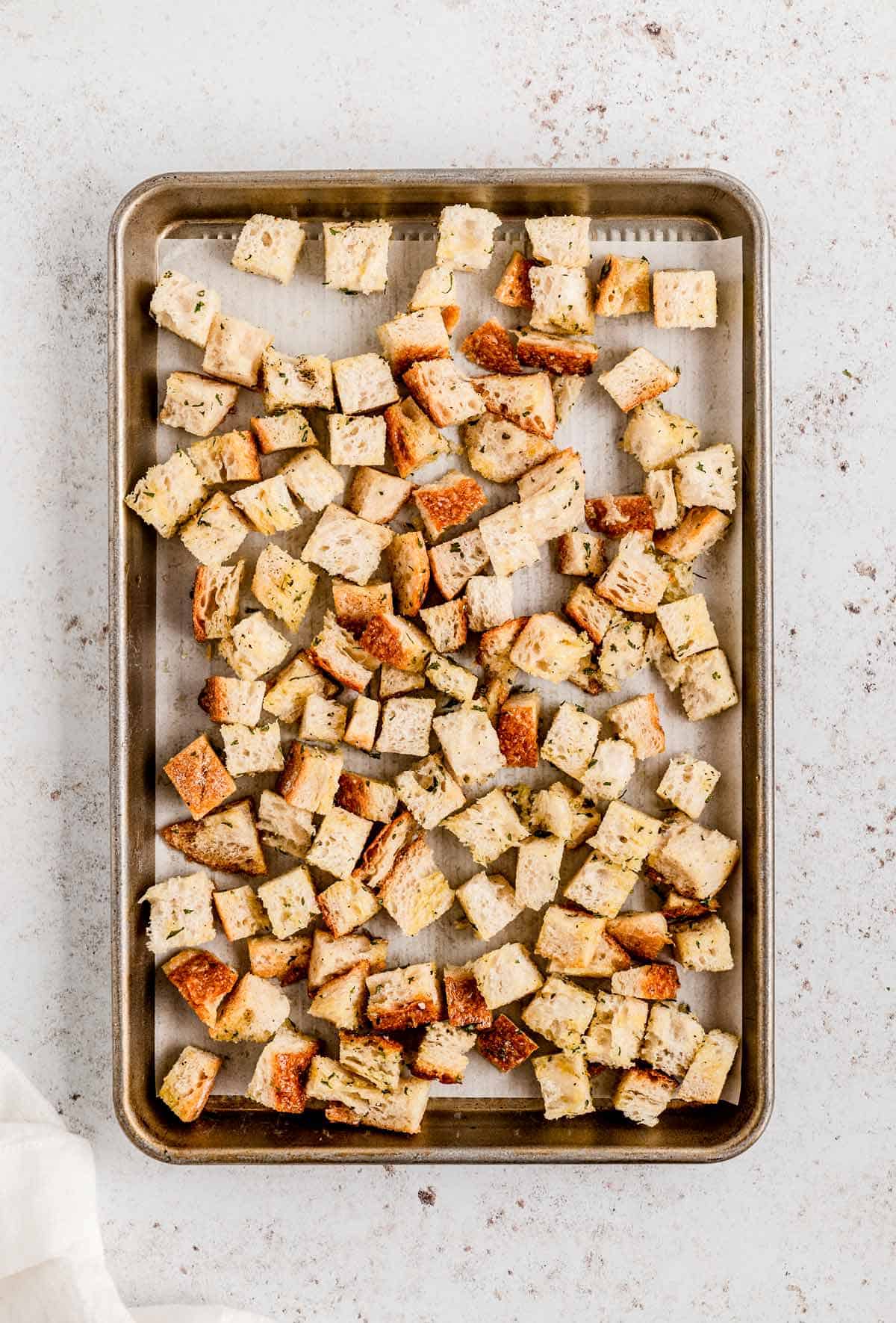 Uncooked croutons on a baking sheet.