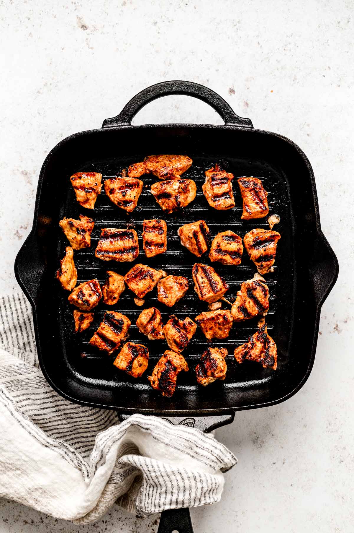 The chicken nuggets grilling in a grill pan.