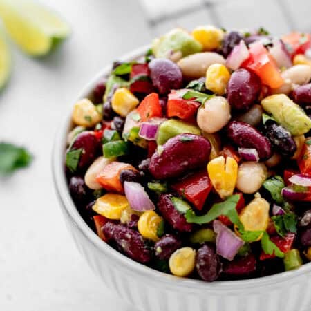 A close up image of mixed bean salad in a small bowl.