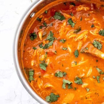 Bird's eye view of pumpkin chicken curry soup in a large pot.