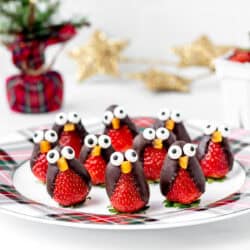 A plate filled with chocolate covered strawberry penguins.
