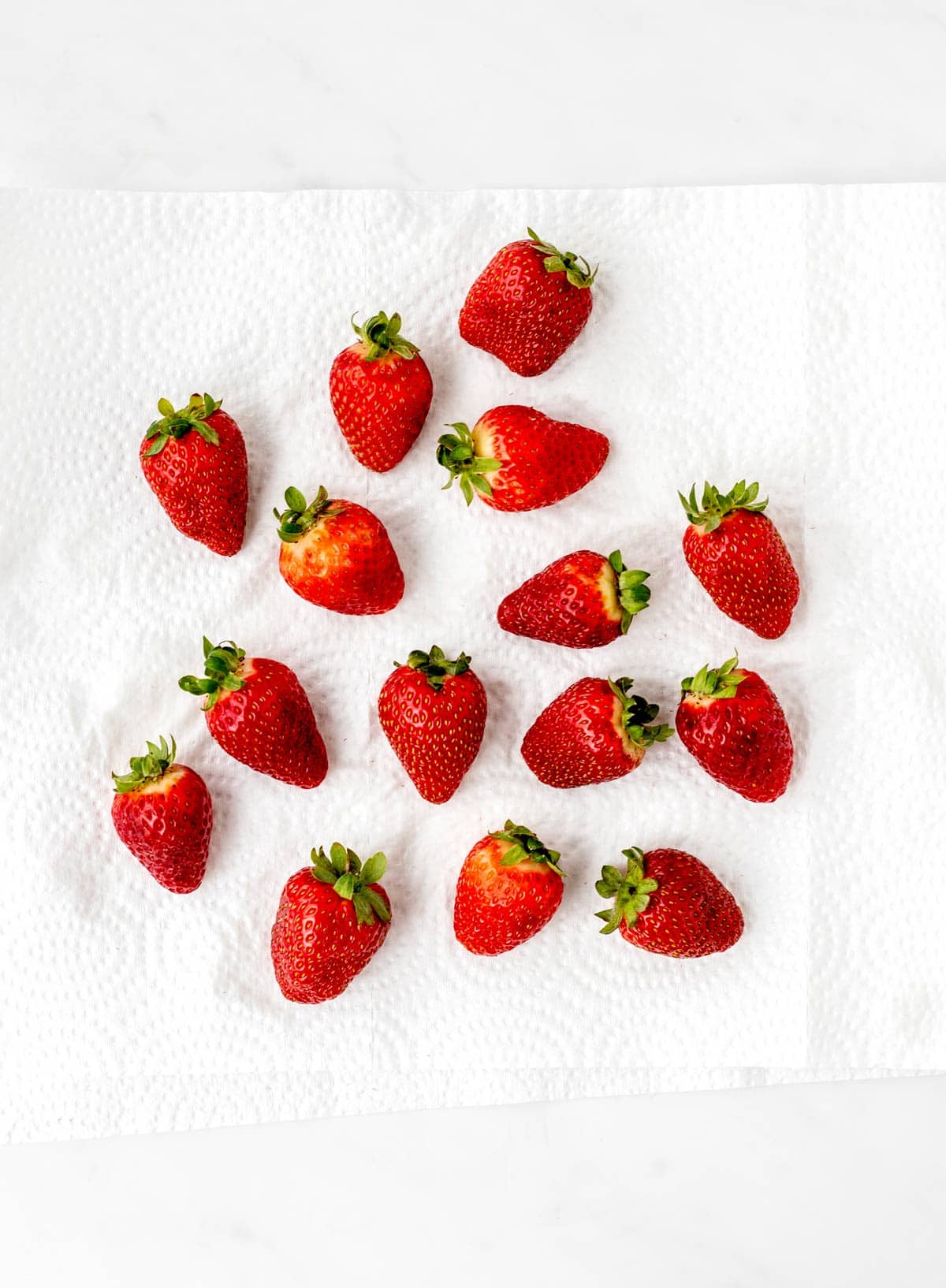 Strawberries drying on a piece of paper towel.