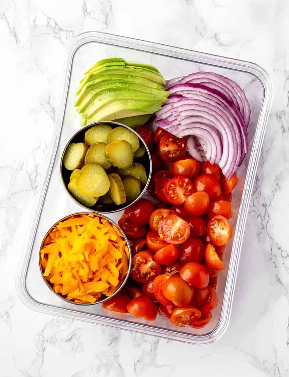 Burger salad toppings in a meal prep container.