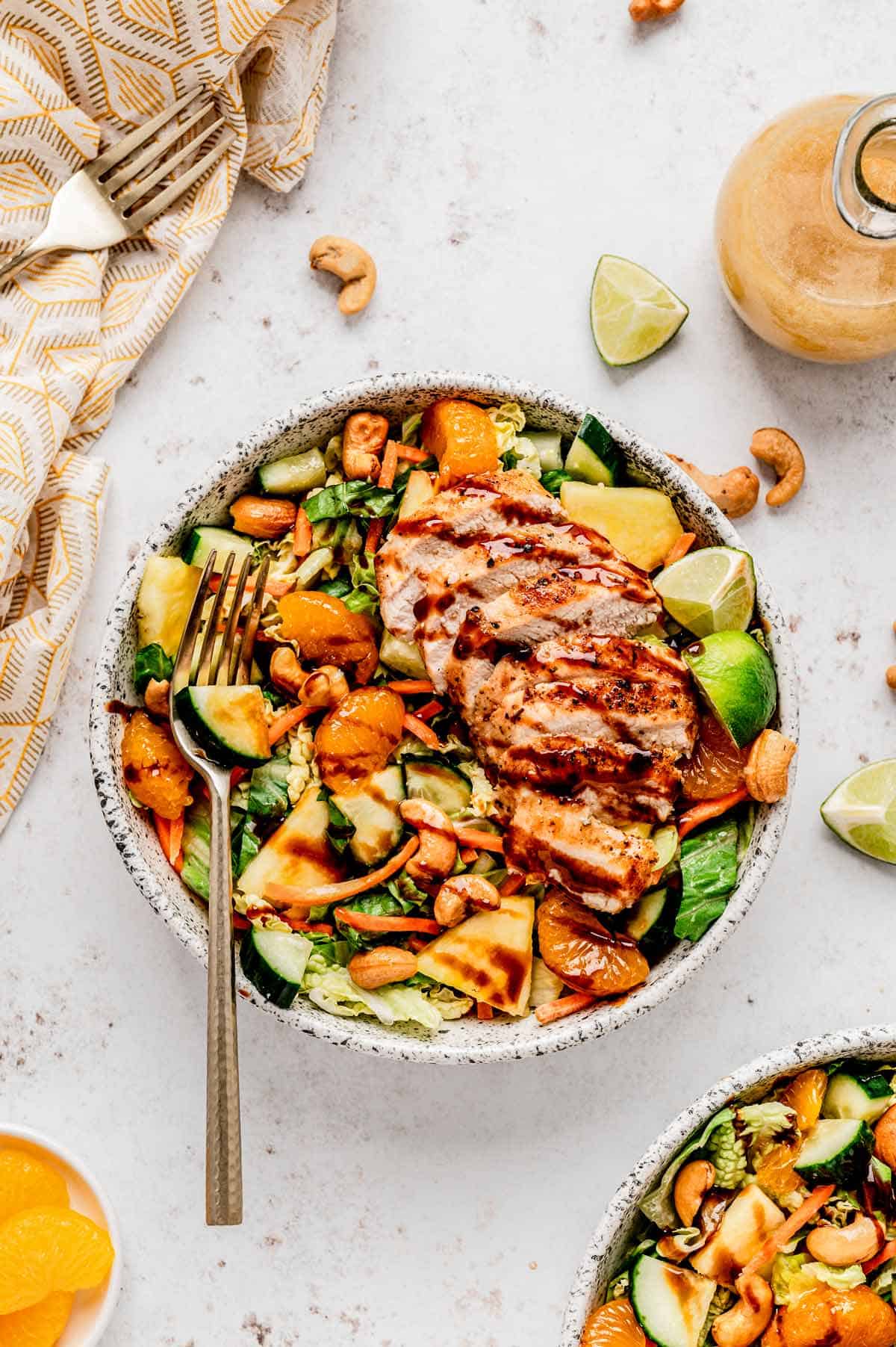 Bird's eye view of Chinese chicken cashew salad with a fork and some dressing.