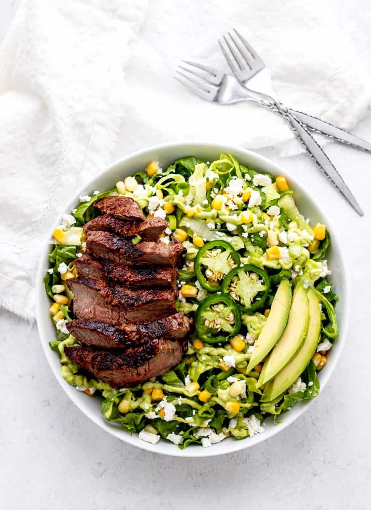 Bird's eye view of steak avocado salad in a bowl.
