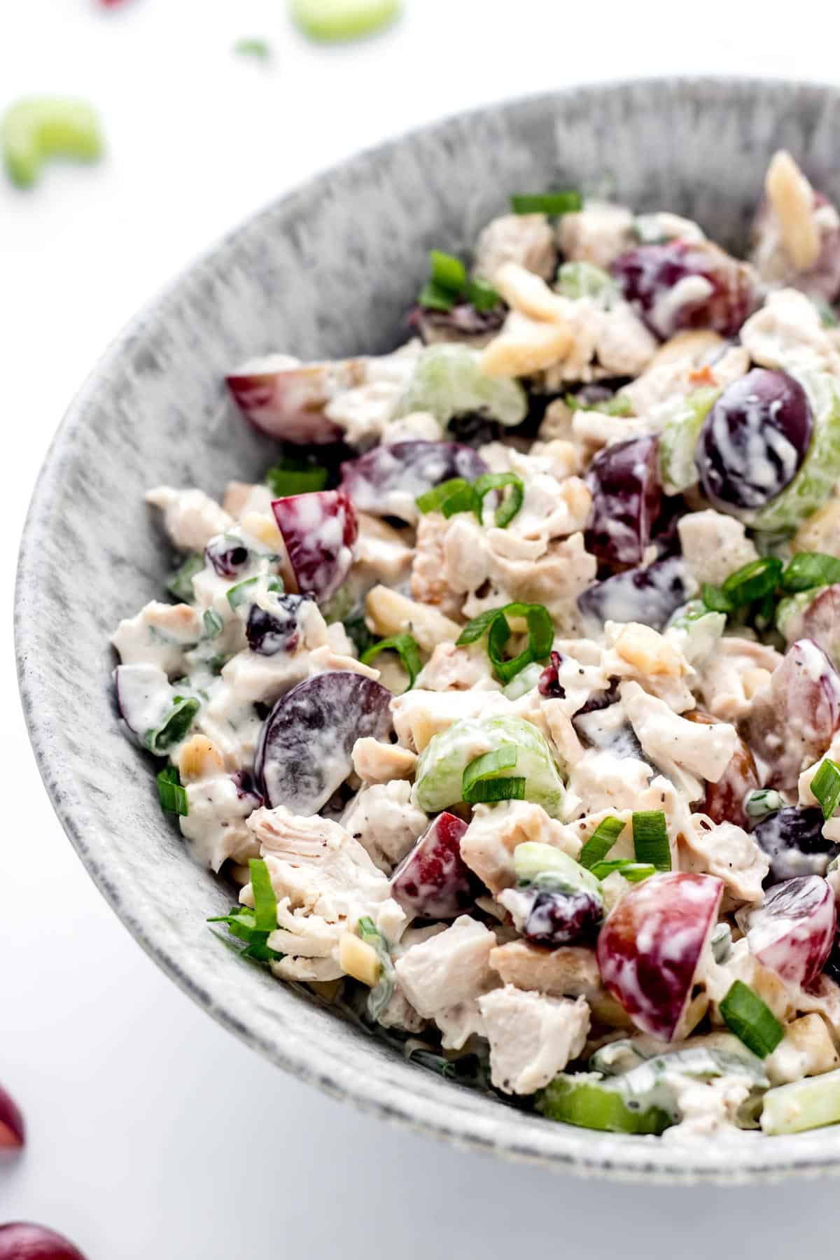 A bowl of chicken salad with grapes and almonds.