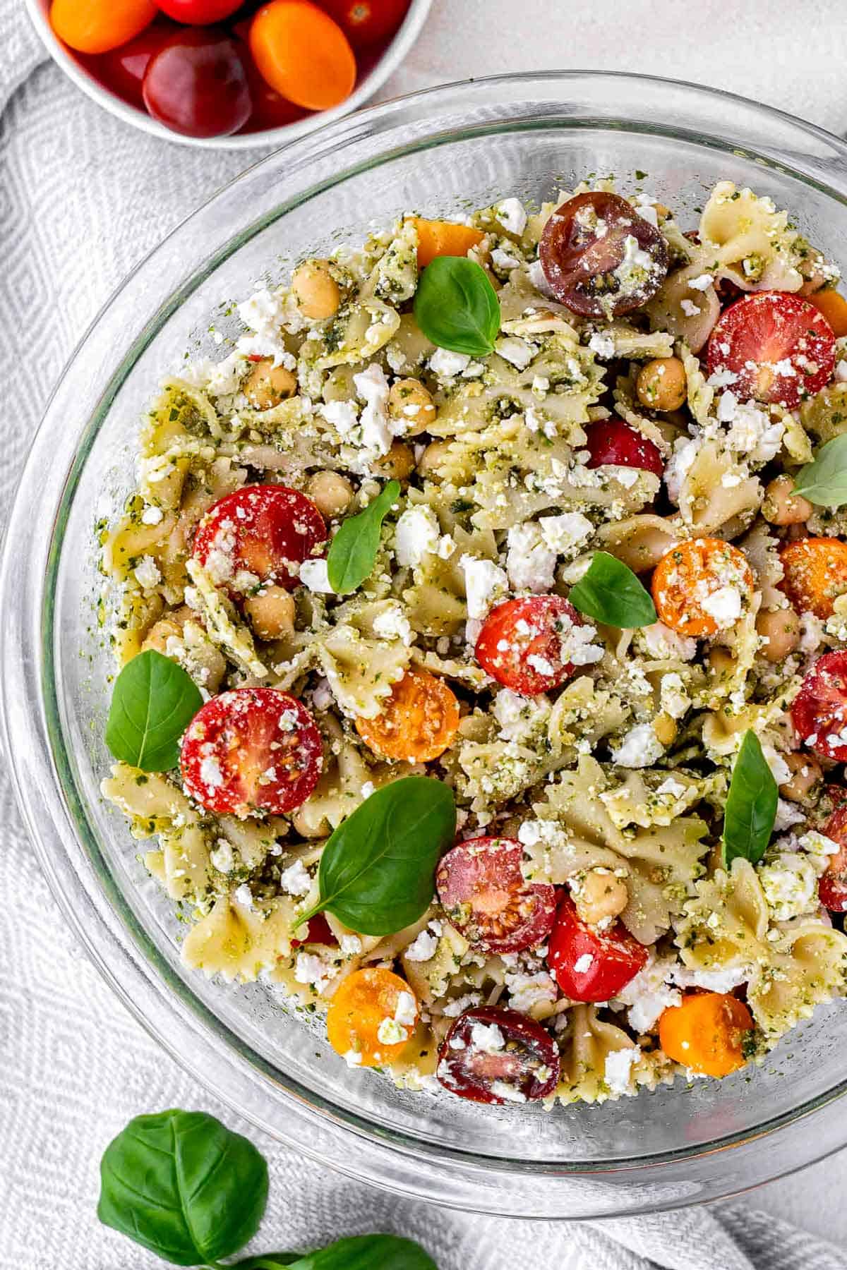 Bird's eye view of protein pesto pasta salad in a large glass bowl.