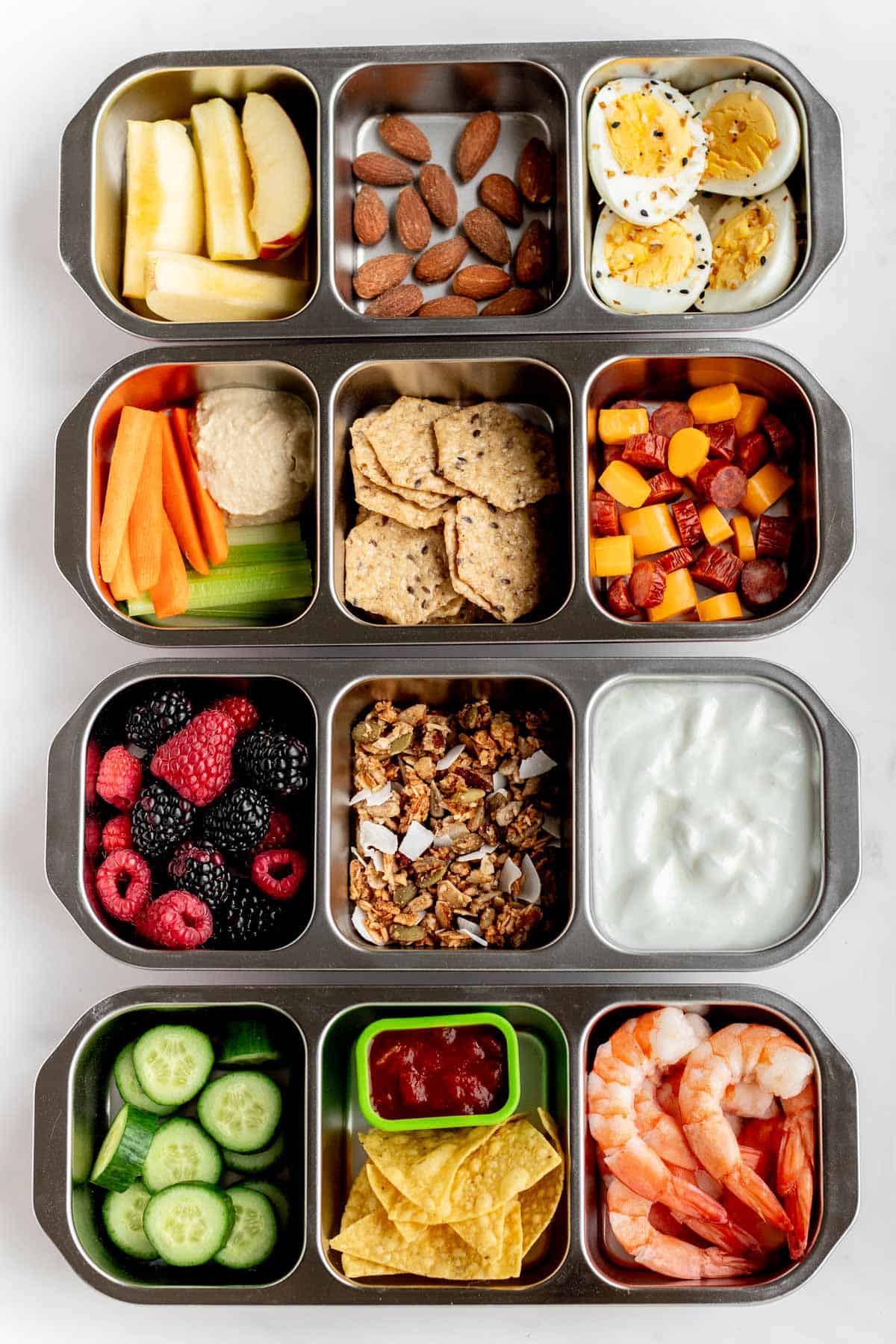 Bird's eye view of four different protein snack box ideas.