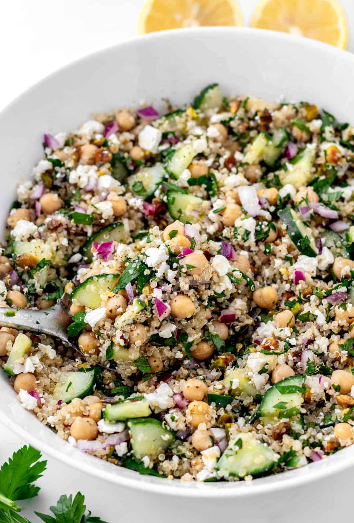A serving spoon digging into a bowl of Jennifer Aniston quinoa salad.