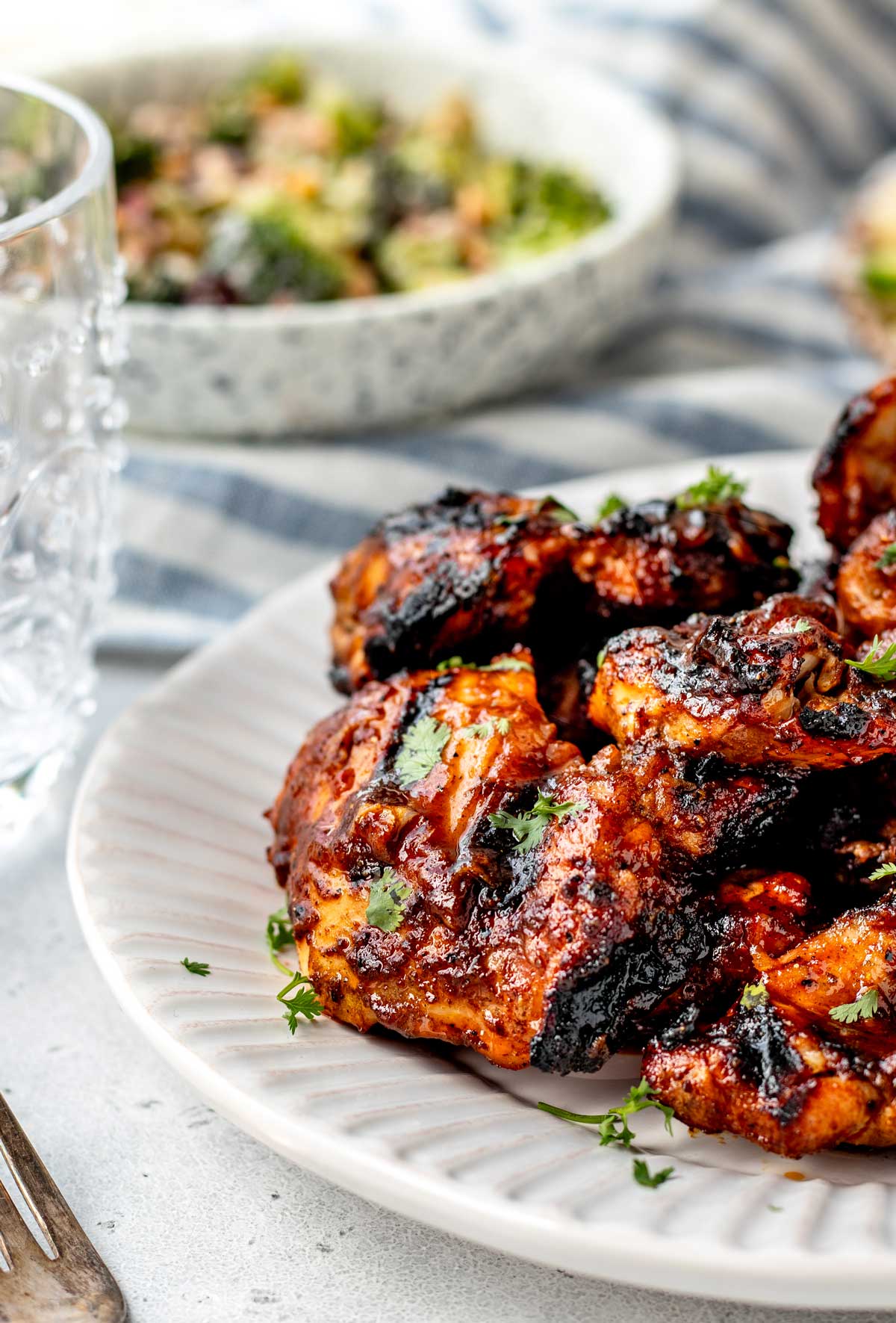 Sticky BBQ chicken thighs on a plate ready to serve.