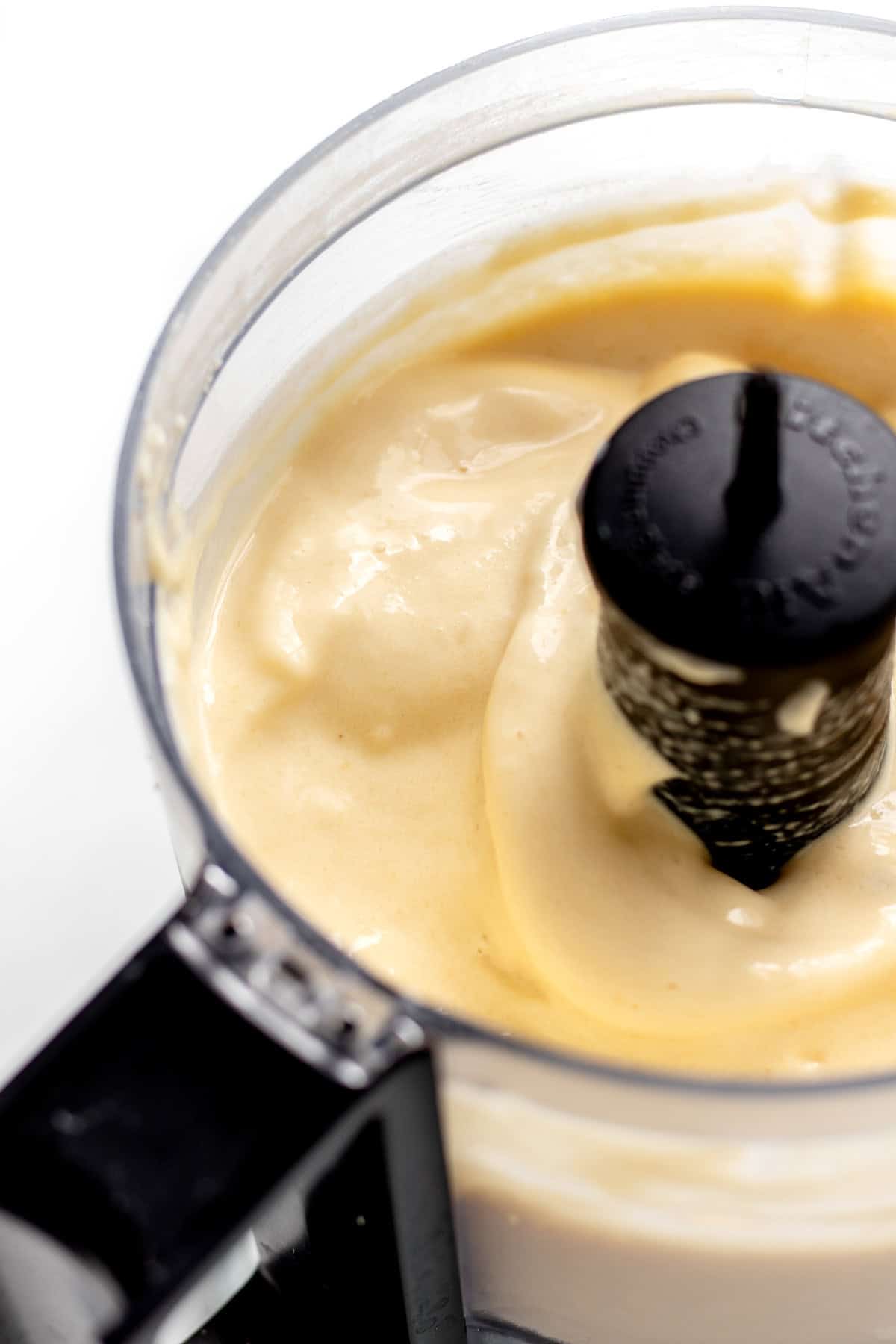 Close up image of the creamy mango protein whip in a mini food processor.