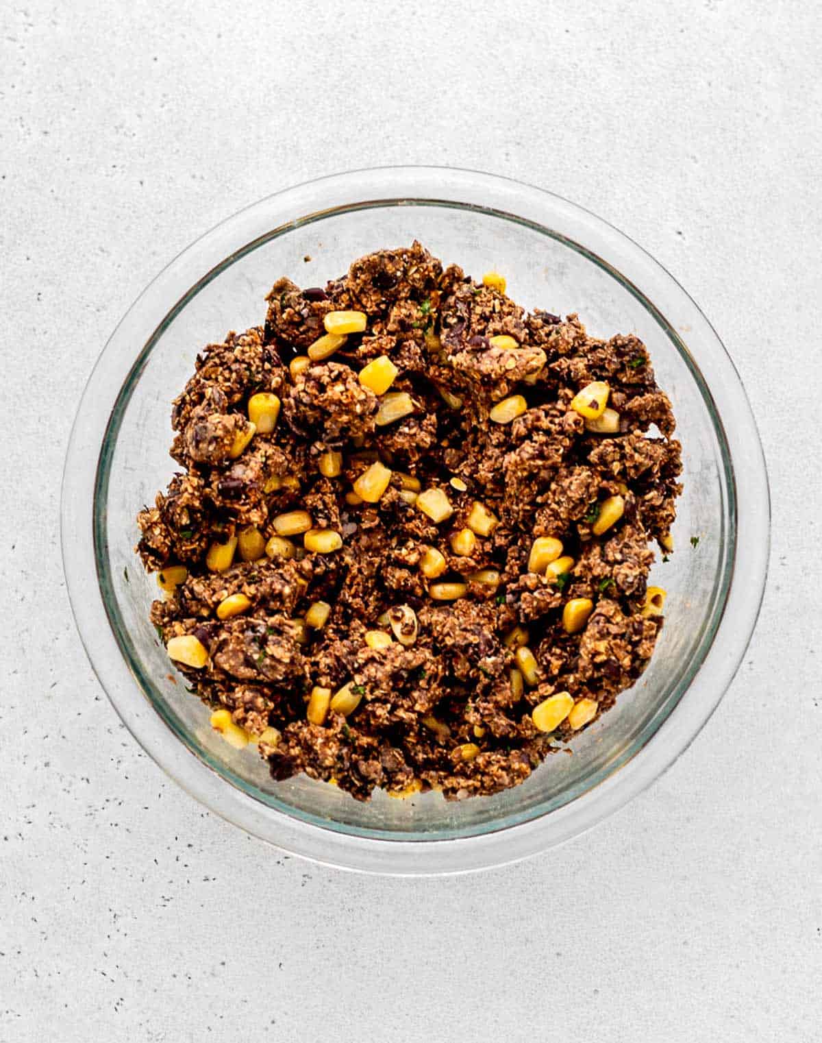A bowl with the bean burger mixture mixed with corn.